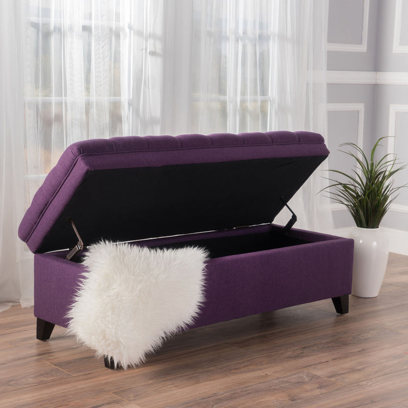 Noble House Juliana storage ottoman with birch wood legs, upholstered in soft fabric, serving as a stylish storage and seating solution.
