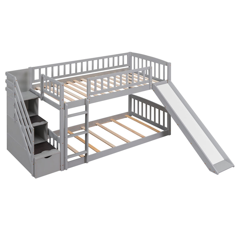 Gray DreamHaus twin over twin bunk bed with stairway, two drawers, and slide, featuring a sturdy frame and safety rails.