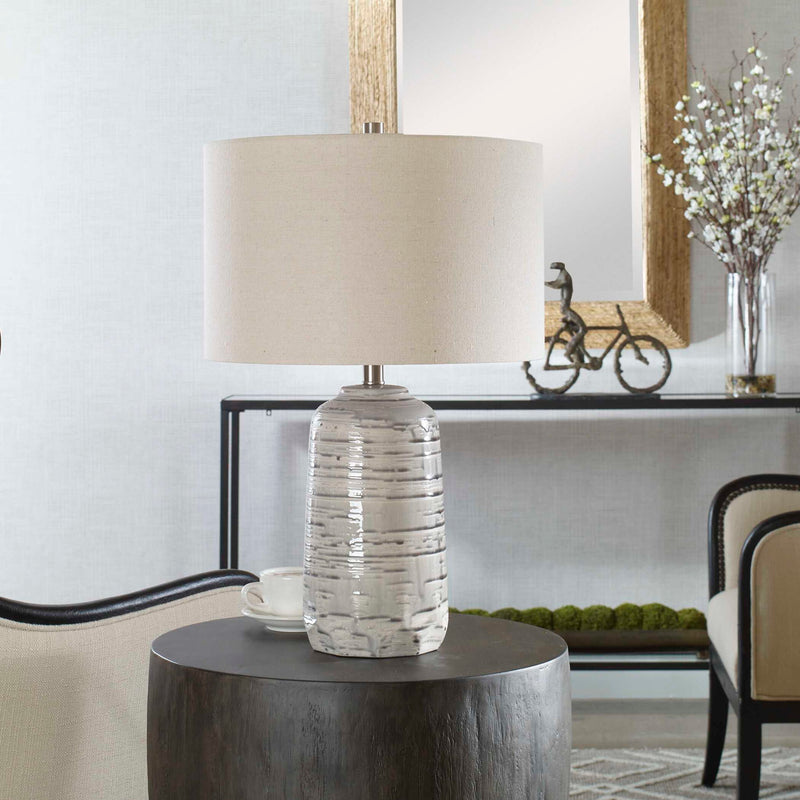Uttermost Cyclone ivory table lamp with textured ceramic base and fabric shade, ideal for modern or contemporary decor.
