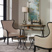Uttermost Sandy wing back armchair in beige and dark brown fabric with plush cushioning and elegant wooden legs.