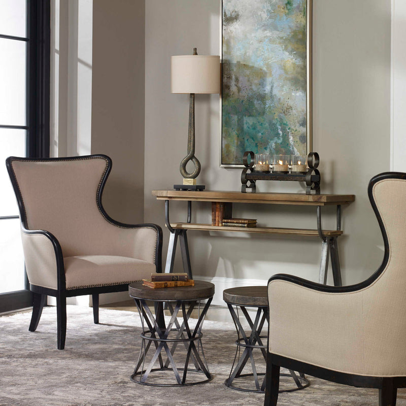 Uttermost Sandy wing back armchair in beige and dark brown fabric with plush cushioning and elegant wooden legs.