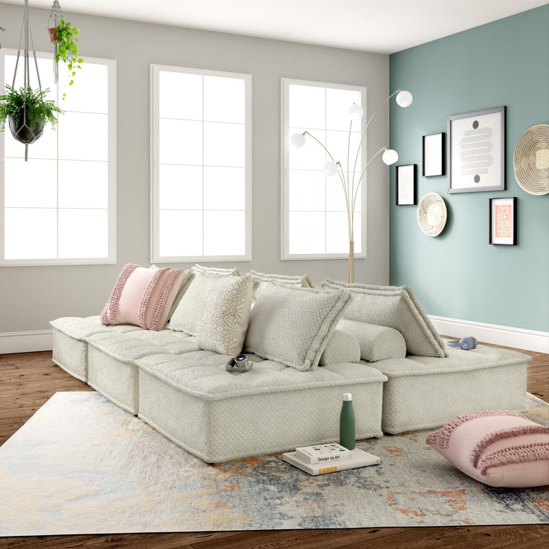 Signature Design by Ashley stationary sectional with plush cushions and a modern fabric finish, shown in a spacious living room setting.