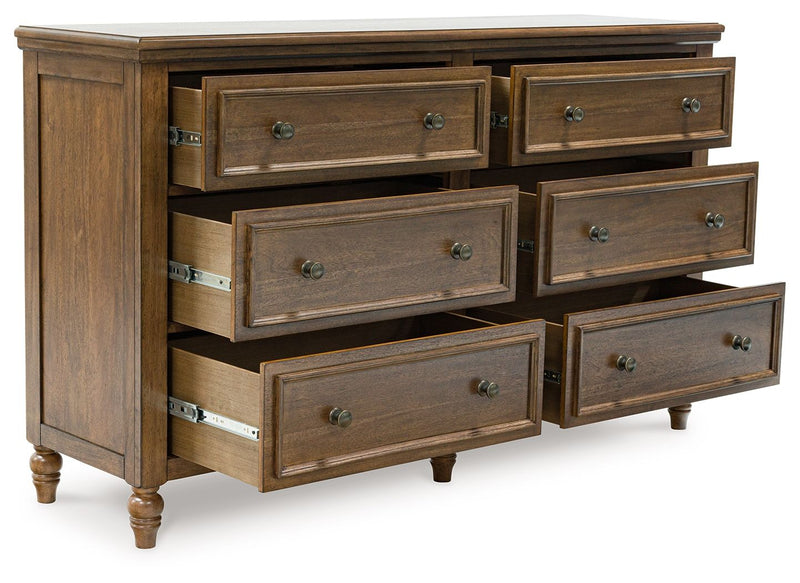 Benchcraft Sturlayne 6-piece panel bedroom set with a bed, nightstands, dresser, and mirror in a modern bedroom scene.