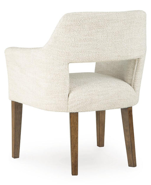 Set of two Benchcraft Marxmore beige and brown upholstered dining arm chairs with padded seats and armrests.