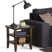 Handcrafted Acadian end table by Simpli-Home featuring a rustic wooden surface and sturdy legs in a cozy living space.