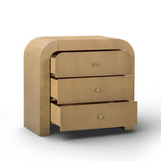 TOV Furniture Hump bedside chest with a sleek wooden finish and modern handles, positioned beside a bed in a contemporary bedroom.