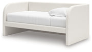 Upholstered day bed from Signature Design by Ashley®, featuring a cozy fabric-covered frame and plush cushions.