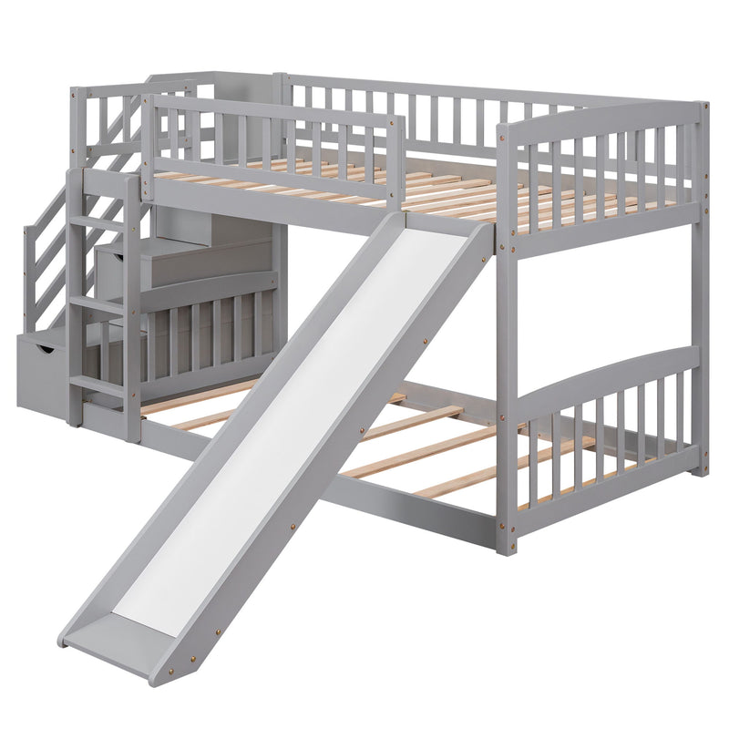 Gray DreamHaus twin over twin bunk bed with stairway, two drawers, and slide, featuring a sturdy wooden frame and safety rails.