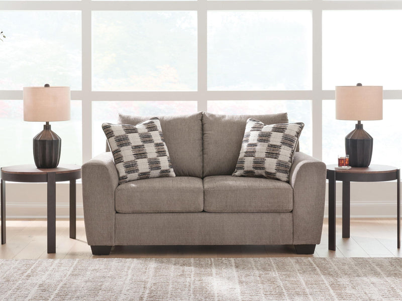 Benchcraft® Loreo stationary loveseat with plush fabric and cushioned armrests, ideal for cozy living room seating.