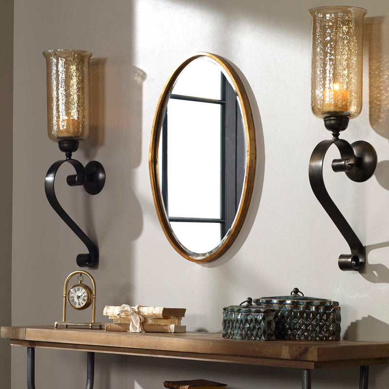 Herleva gold oval wall mirror by Uttermost, featuring a sleek modern design with a gold finish and a stylish oval shape.
