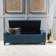 Noble House Guernsey storage ottoman with tufted top, beige fabric, and sturdy wooden legs, serving as stylish bedroom or living room storage.