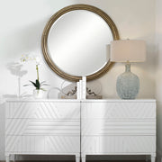Uttermost Spera round gold wall mirror with a sleek, modern frame, reflecting a stylish interior decor element.