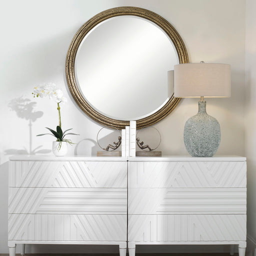 Uttermost Spera round gold wall mirror with a sleek, modern frame, reflecting a stylish interior decor element.