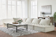 Signature Design by Ashley stationary sectional sofa with plush cushions and modern design, shown in a cozy living room setting.
