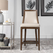 Uttermost Purcell beige counter stool with upholstered seat and wooden legs, designed for 24-27 inch counter height.