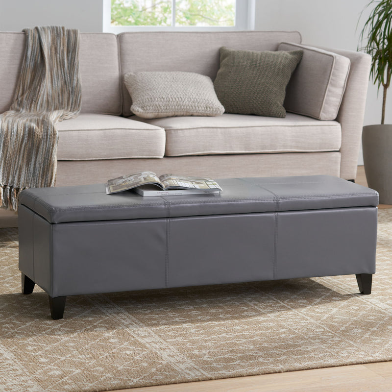 Noble House Glouster contemporary storage ottoman with plush fabric and wooden legs, serving as a stylish ottoman and storage solution.