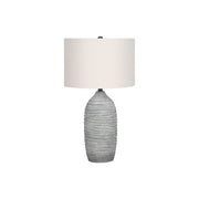 Modern gray and cream resin table lamp by 8th Street with sleek, contemporary design and soft lighting.