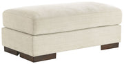 Signature Design by Ashley Maggie upholstered ottoman with plush fabric and wooden legs, versatile for living room or bedroom decor.