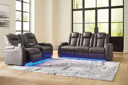 Signature Design by Ashley reclining living room set with plush sofas and loveseats, featuring padded armrests and reclining mechanisms.