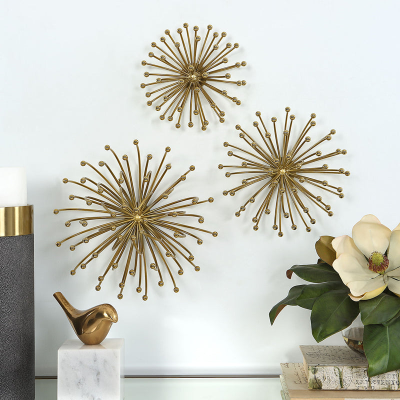Set of three gold metal wall decor pieces by Uttermost, featuring modern geometric designs for stylish wall accent.