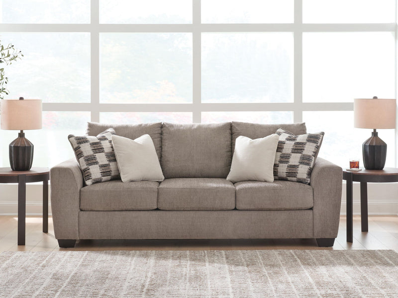 Benchcraft stationary sofa with plush fabric upholstery and modern design, featuring wide armrests and comfortable cushioning.