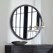 Round industrial wall mirror by Uttermost featuring a metal frame with a vintage finish.