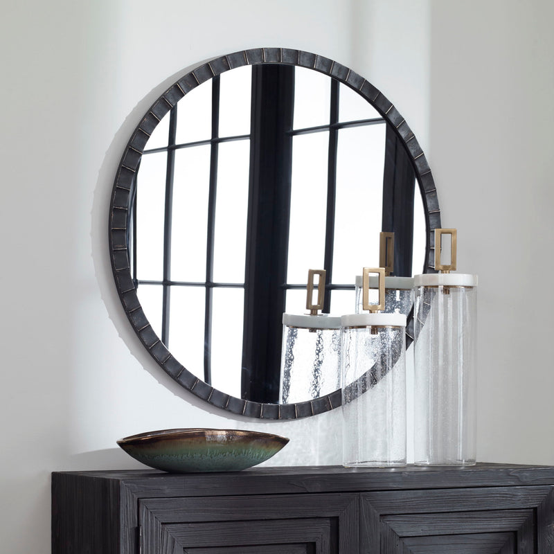 Round industrial wall mirror by Uttermost featuring a metal frame with a vintage finish.