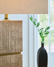 Beige Poly Table Lamp by Signature Design by Ashley®, featuring a modern design with a rounded base and fabric shade.