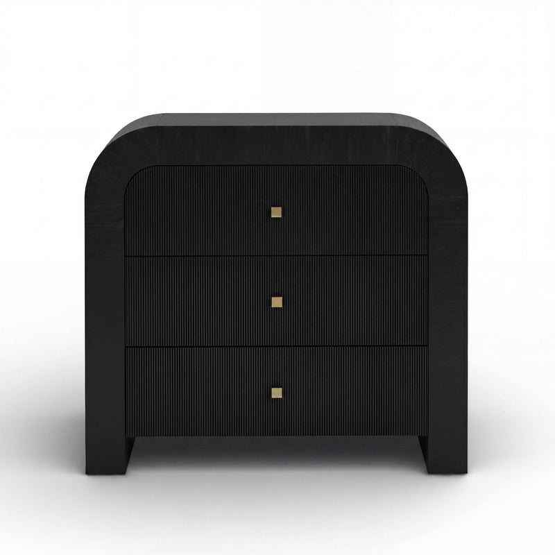 TOV Furniture Hump bedside chest with drawers, wooden finish, and modern design, placed beside a bed in a cozy bedroom setting.