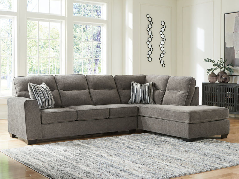 Olten Benchcraft® stationary sectional sofa with plush cushions and modern design, shown in a living room setting.