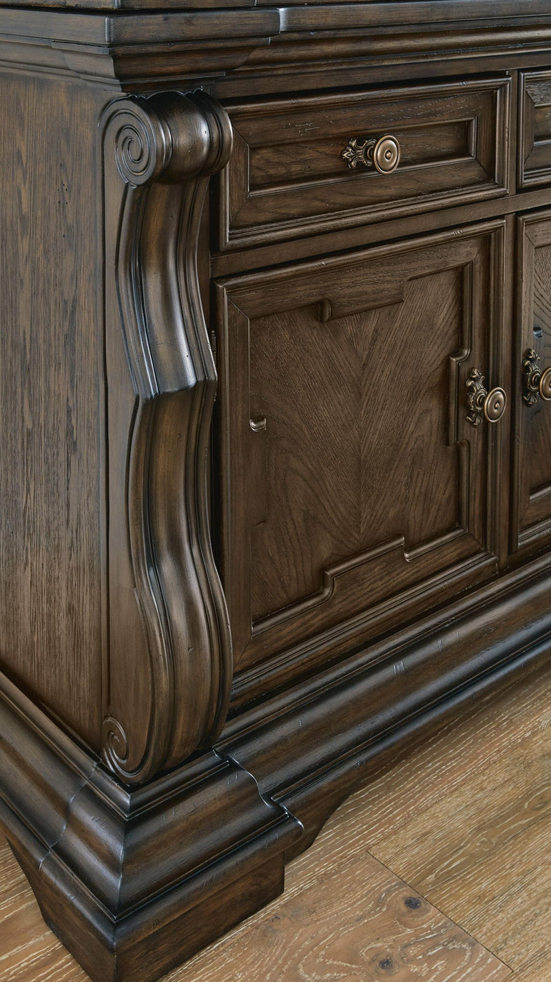 Dark brown Maylee dining buffet and hutch by Signature Design Ashley, featuring glass-paneled upper cabinets and spacious lower storage.