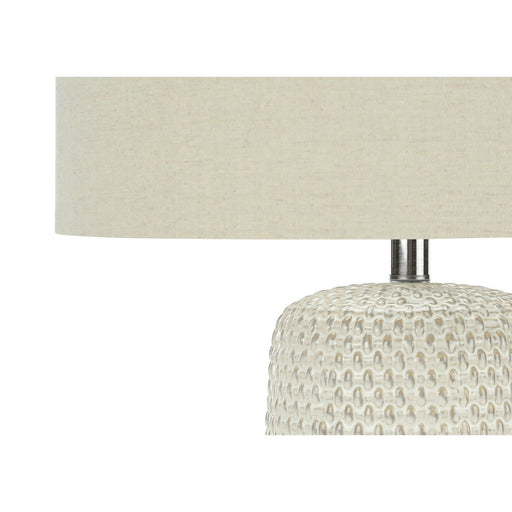 Cream ceramic and resin contemporary table lamp by 8th Street, featuring a sleek modern design and soft ambient lighting.