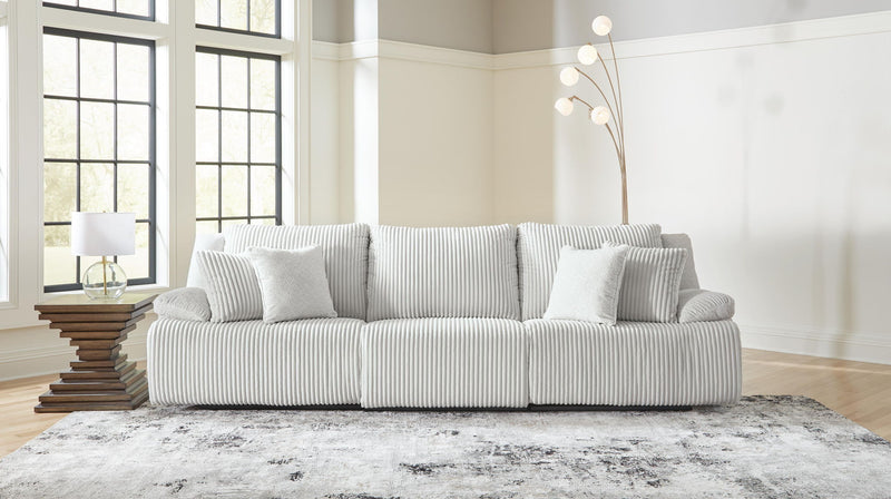 Signature Design by Ashley reclining sectional with plush cushions and reclining seats in a modern living room setting.