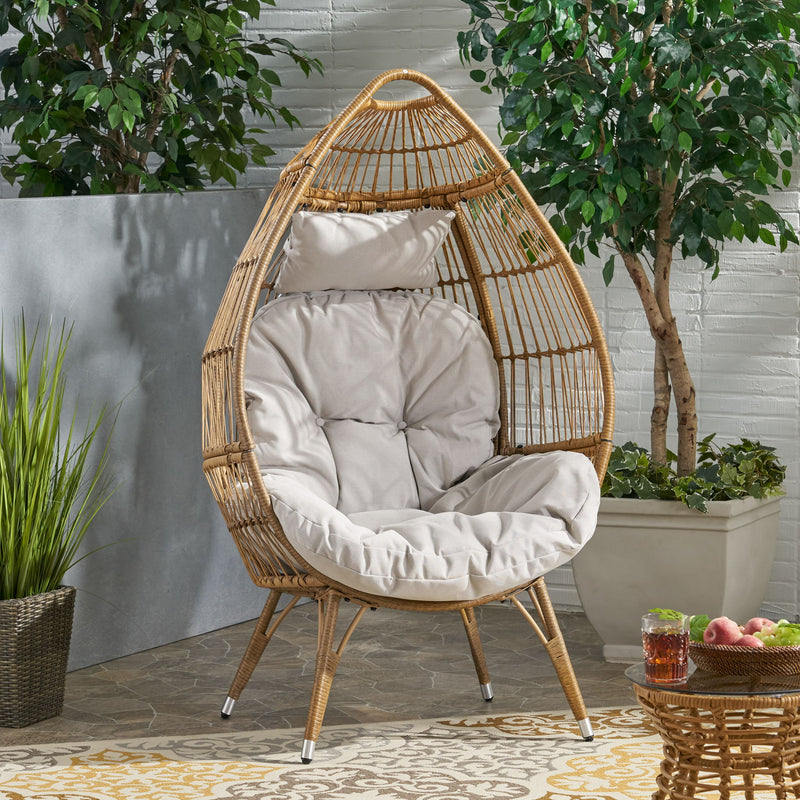 Noble House basket accent chair with teardrop shape and water-resistant cushion in natural wicker finish.
