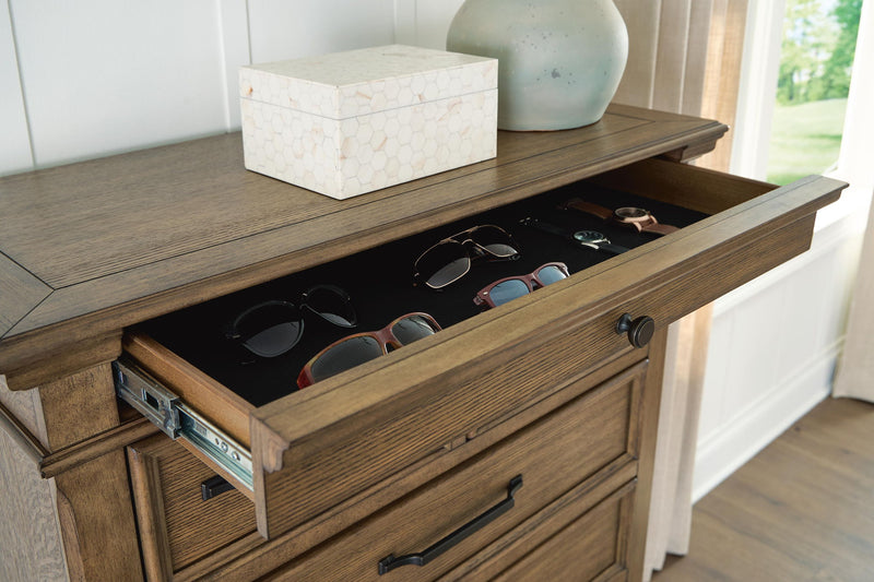 Medium brown Karallin Seven Drawer Chest from Signature Design by Ashley®, with sleek accent chest design and silver handles.