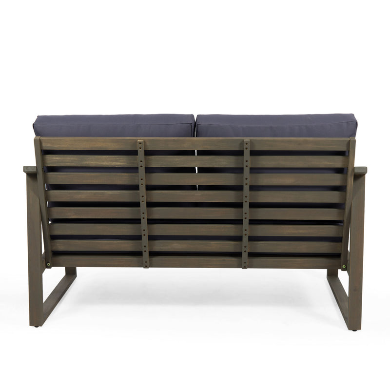 Noble House Samwell outdoor 2-piece coffee table and loveseat set with woven rattan design and neutral cushions.