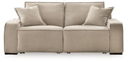 Benchcraft® Carceri reclining sectional with plush cushions, neutral fabric upholstery, and multiple reclining seats in a modern living room setting.