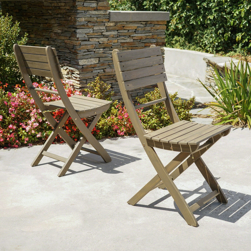 Set of two Noble House outdoor foldable wood dining chairs with slat design, ideal for patio or garden seating.