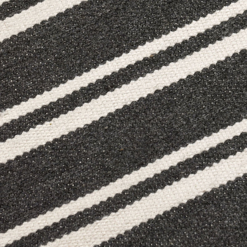 Classic Home Palma stripe area rug with bold black and white geometric pattern on a textured fabric background.