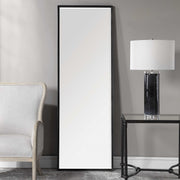 Uttermost Callan Leaner Mirror in black with sleek modern frame, standing tall against a neutral background.