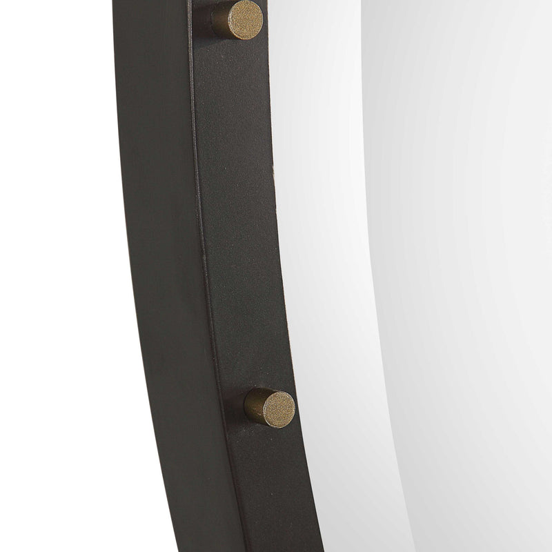 Benedo round black wall mirror by Uttermost with a sleek, modern frame, hanging on a plain wall.