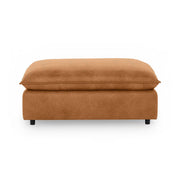 Classic Home Caplan upholstered ottoman with a plush fabric cushion and wooden legs, perfect for living room decor.