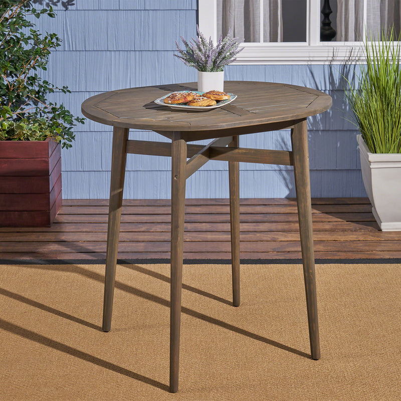 Noble House outdoor acacia wood bar table with slat top, sturdy design suitable for patio or garden seating areas.