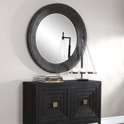 Round black industrial wall mirror by Uttermost with a sleek metal frame, suitable for modern or industrial decor.