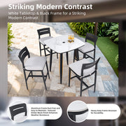 Outdoor bar table with rounded square sintered stone top, umbrella hole, rust-free frame, weatherproof design in Ember Black and White.
