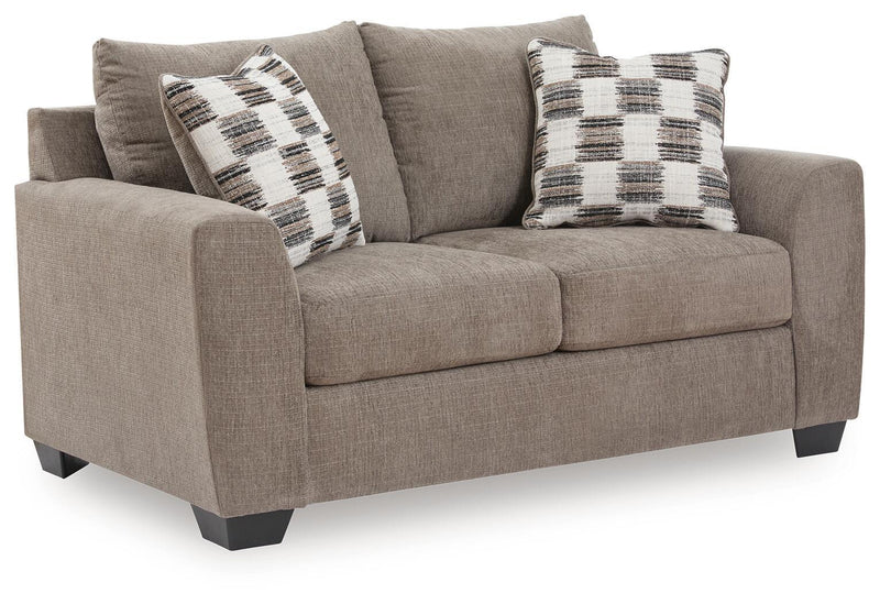 Benchcraft® Loreo stationary loveseat with plush fabric, wide armrests, and cushioned back for comfortable seating.