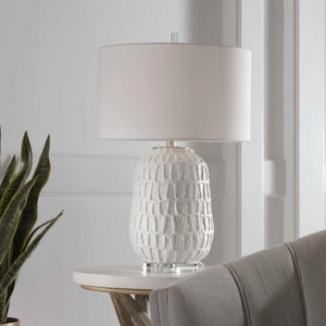 White textured Caelina table lamp by Uttermost featuring a modern design with a sleek finish and cylindrical shape.