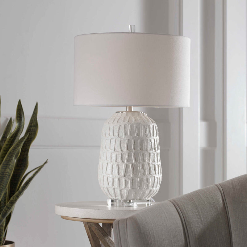 White textured Caelina table lamp by Uttermost featuring a modern design with a sleek finish and cylindrical shape.