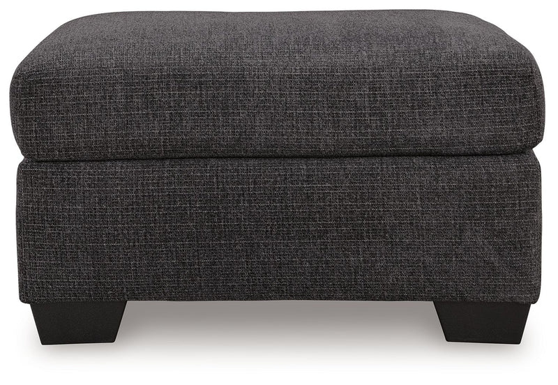 Benchcraft® upholstered ottoman from Loreo collection, featuring a plush, padded fabric top and sturdy wooden legs.