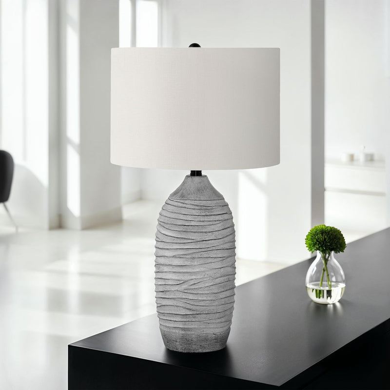 Modern gray and cream resin table lamp with sleek design, perfect for contemporary home décor.